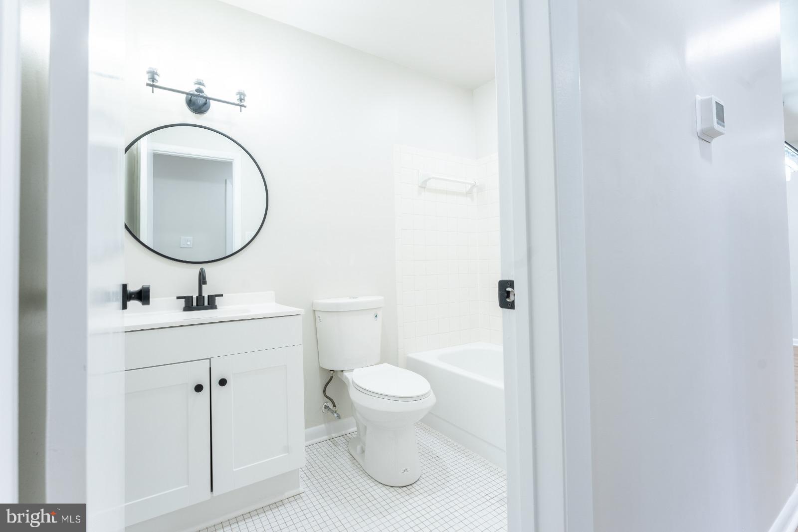 6350 Red Cedar Place, Unit 309 Baltimore, MD 21209 - Photo 27 of 29 a bathroom with a toilet a sink and a mirror