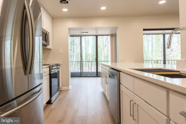a open kitchen with stainless steel appliances granite countertop a refrigerator and a sink
