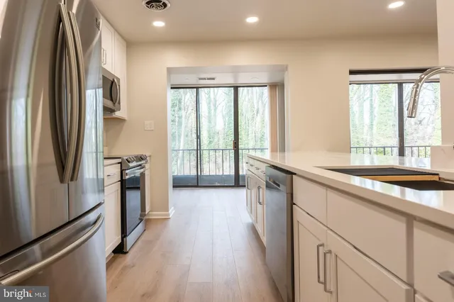 a open kitchen with stainless steel appliances granite countertop a refrigerator and a sink