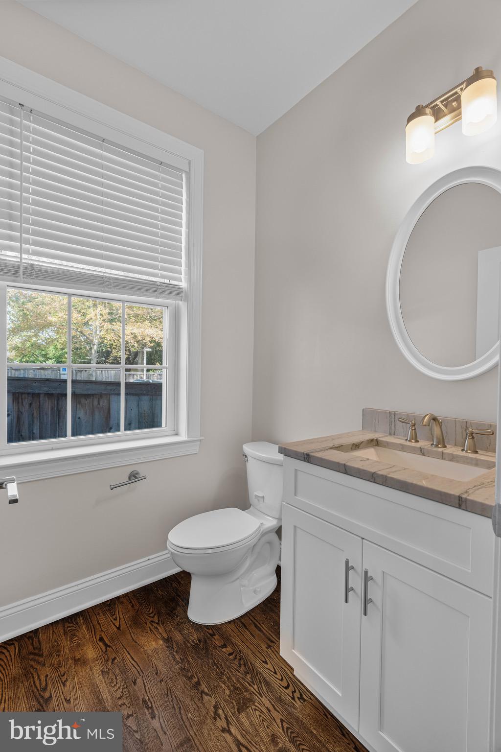 303 # 2 Witherspoon Street Princeton, NJ 08542 - Photo 11 of 31 a bathroom with a granite countertop toilet a sink and a mirror