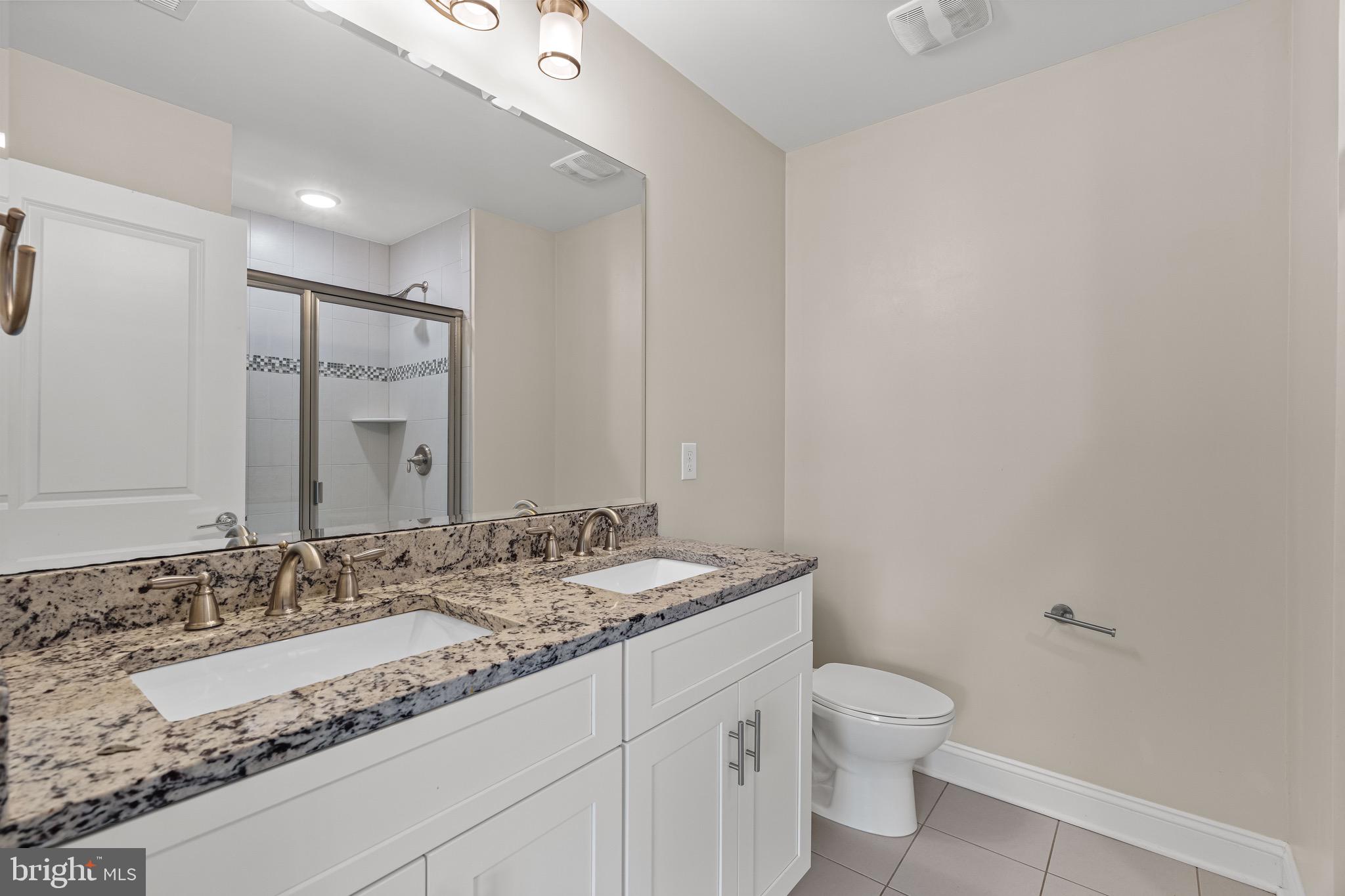 303 # 2 Witherspoon Street Princeton, NJ 08542 - Photo 22 of 31 a bathroom with a granite countertop sink a toilet and a mirror