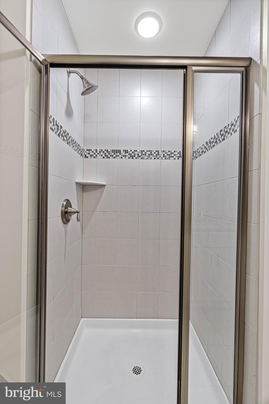 303 # 2 Witherspoon Street Princeton, NJ 08542 - Photo 23 of 31 a bathroom with a glass shower door and a window