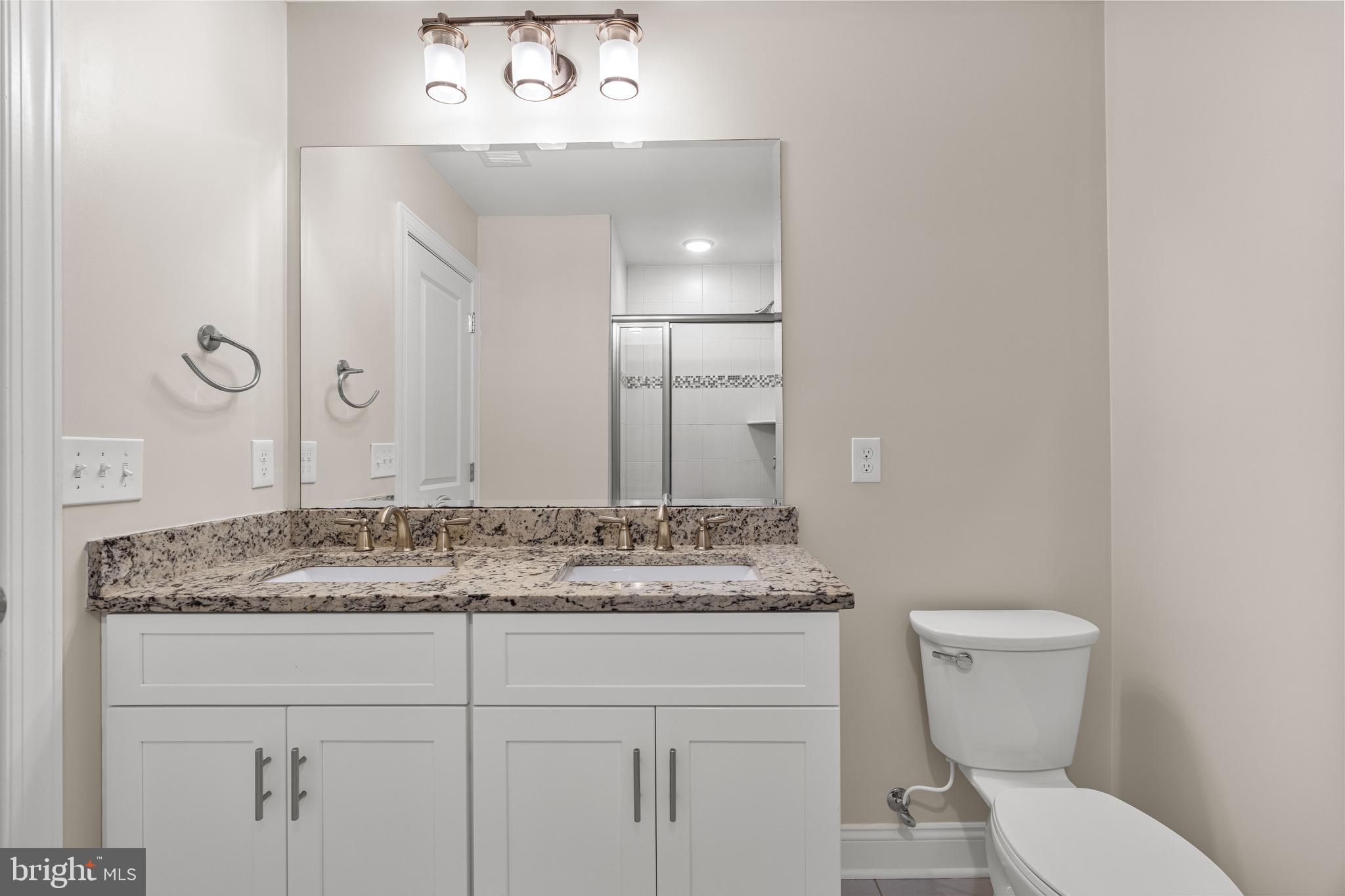 303 # 2 Witherspoon Street Princeton, NJ 08542 - Photo 24 of 31 a bathroom with a granite countertop sink and a toilet