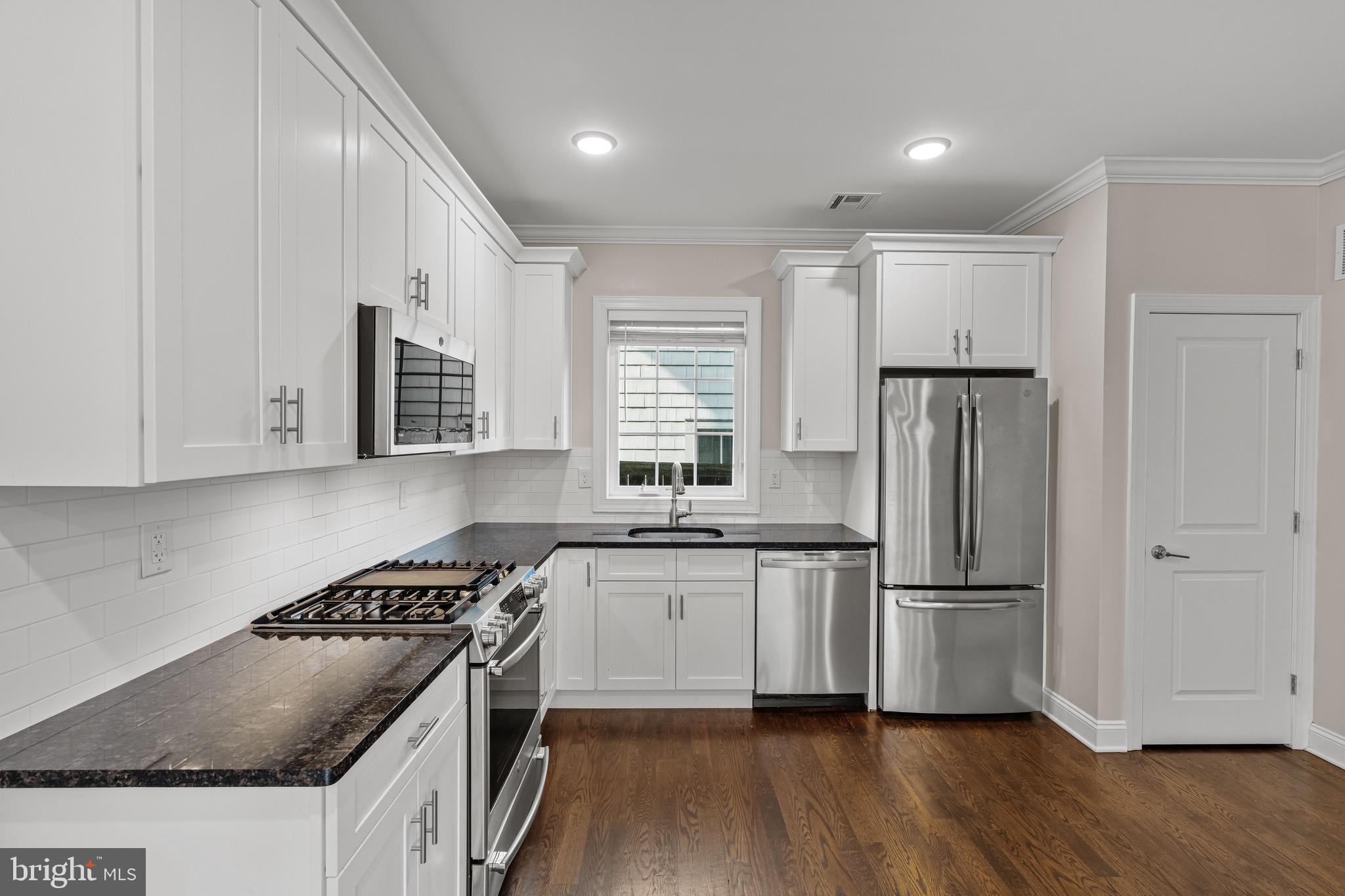 303 # 2 Witherspoon Street Princeton, NJ 08542 - Photo 6 of 31 a kitchen with stainless steel appliances granite countertop a stove a refrigerator and a sink
