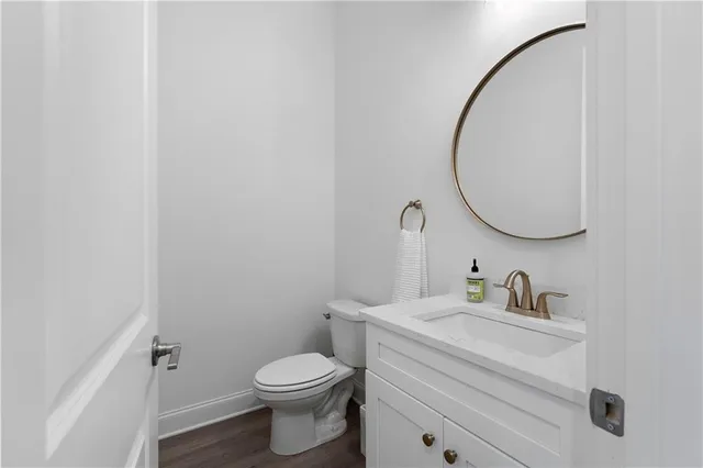 a bathroom with a toilet sink vanity and mirror