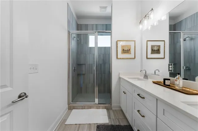 a bathroom with a double vanity sink toilet and shower