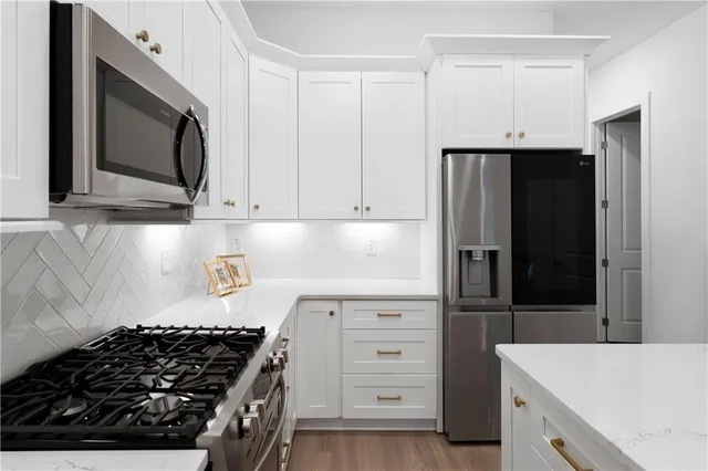 a kitchen with stainless steel appliances a stove a microwave and a refrigerator