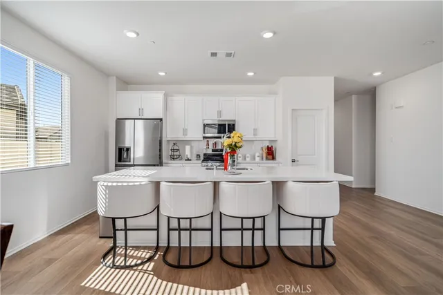 a kitchen with a dining table chairs refrigerator and cabinets