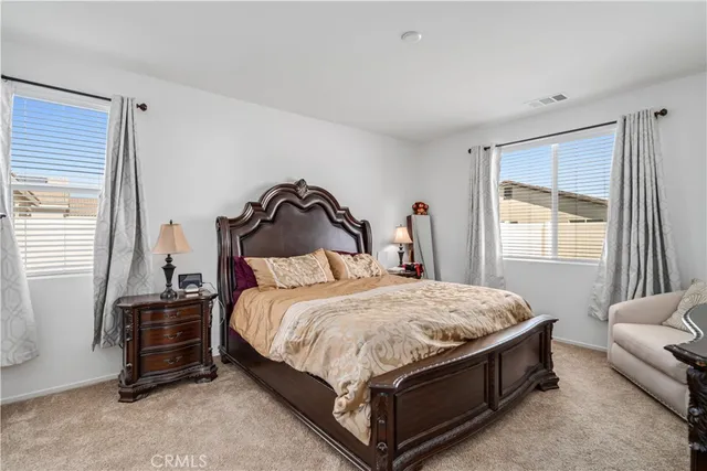 a bedroom with a bed a couch and a window