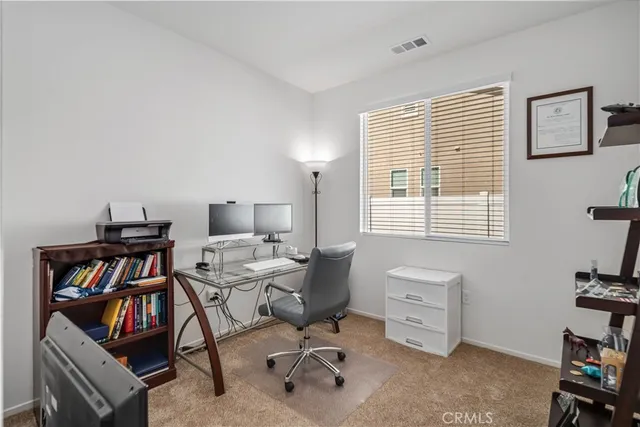 a view of a workspace with furniture and a window