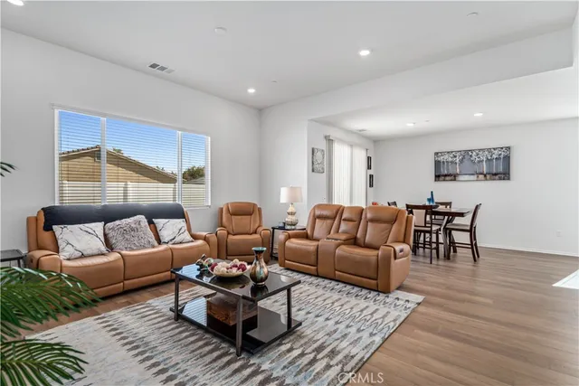 a living room with furniture wooden floor and window