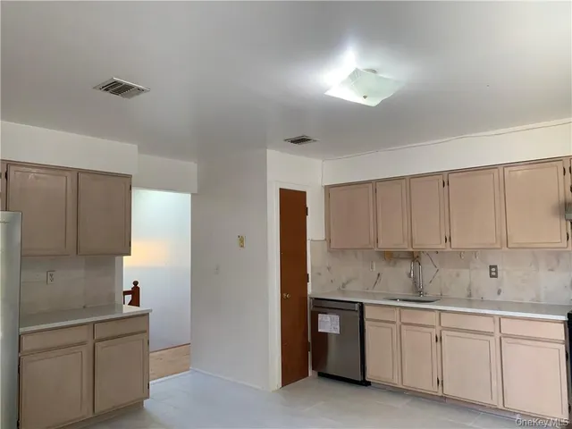a kitchen with granite countertop white cabinets and stainless steel appliances
