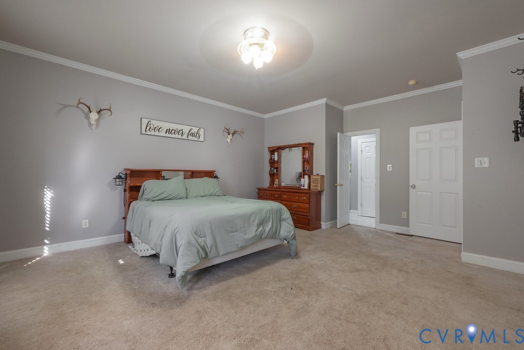 15438 West Patrick Henry Road Montpelier, VA 23192 - Photo 15 of 45 a spacious bedroom with a bed and a lamp with window