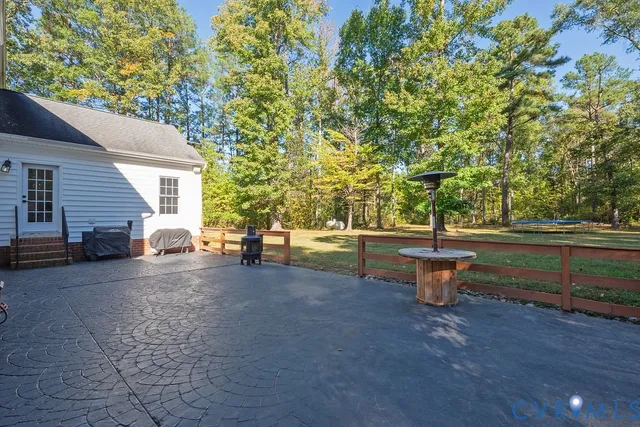 a view of a patio with table and chairs and a barbeque