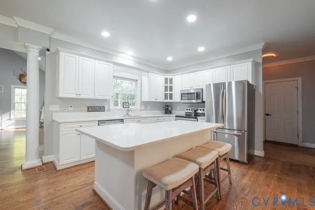 a kitchen with refrigerator cabinets and wooden floor