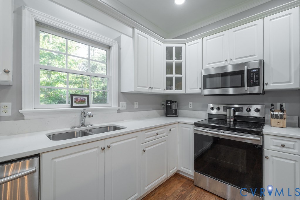 15438 West Patrick Henry Road Montpelier, VA 23192 - Photo 7 of 45 a kitchen with stainless steel appliances granite countertop white cabinets a sink a stove a microwave a sink and dishwasher with wooden floor