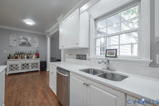 a kitchen that has a sink cabinets counter space and a window