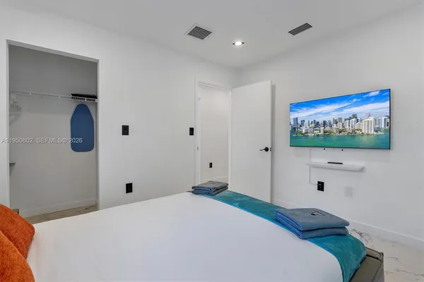 a bedroom with a bed and a flat screen tv