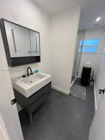 a bathroom with a sink a mirror and shower