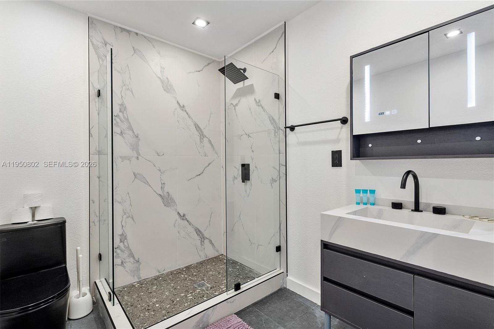 270 Northwest 41st Street Miami, FL 33127 - Photo 22 of 30 a bathroom with a sink a mirror and shower