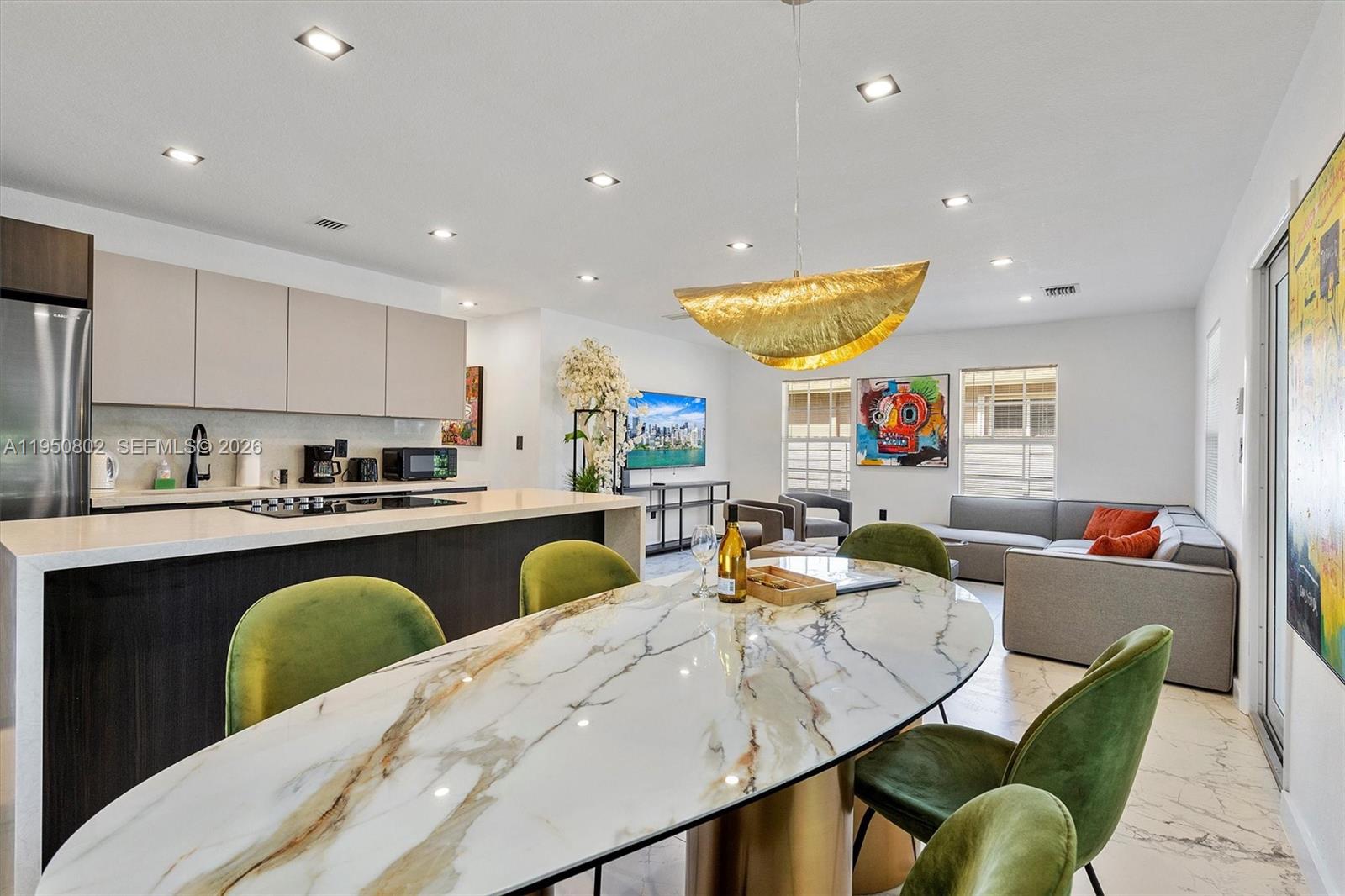 270 Northwest 41st Street Miami, FL 33127 - Photo 26 of 30 a kitchen with stainless steel appliances granite countertop a table and chairs
