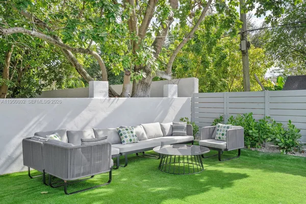 a view of a couches in a patio with a yard