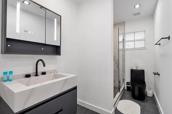 a bathroom with a sink toilet and mirror
