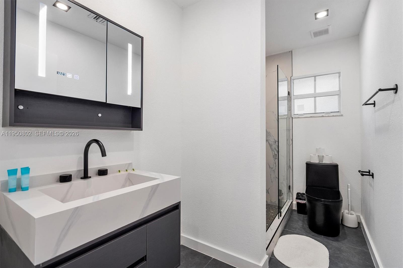 270 Northwest 41st Street Miami, FL 33127 - Photo 5 of 30 a bathroom with a sink toilet and mirror