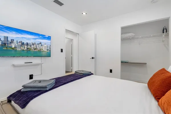 a bedroom with a large bed and a flat screen tv