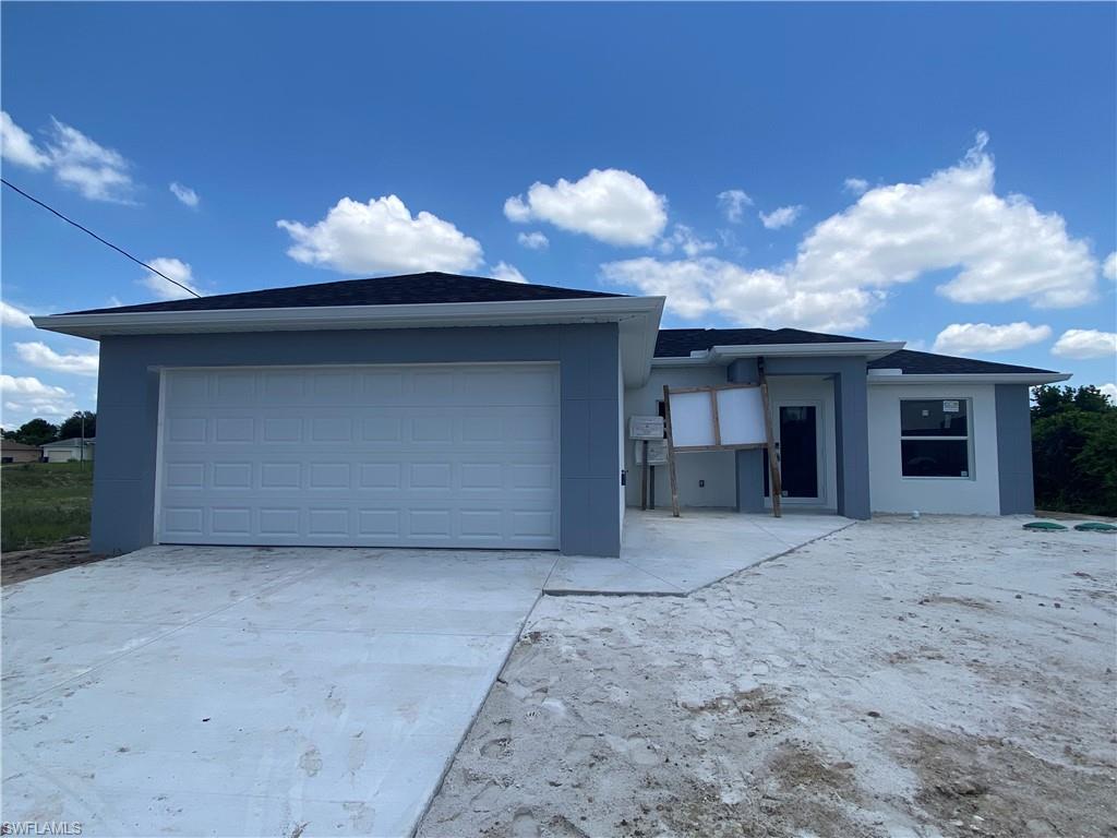 2812 15th Street Southwest Lehigh Acres, FL 33976 - Photo 9 of 13 a view of a house with a yard and a garage