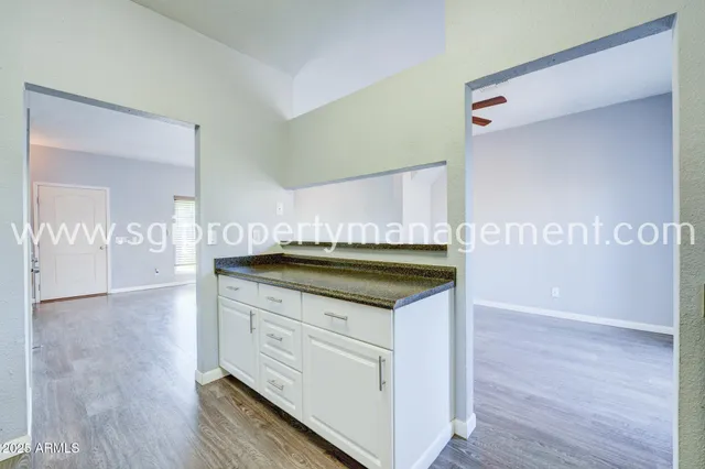a kitchen with granite countertop a sink and cabinets