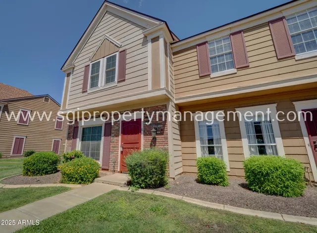 front view of a brick house with a yard