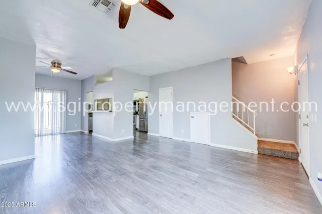 a view of an empty room with window and wooden floor
