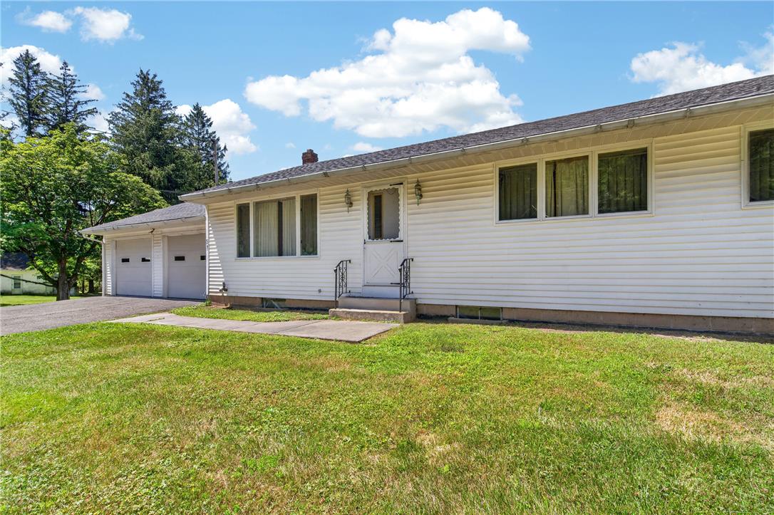 51 Reynolds Road Tamaqua, PA 18252 - Photo 53 of 71 A classic ranch home presents with a dual-car garage and a verdant lawn under an open sky.