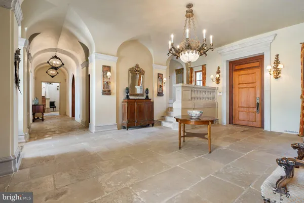 a living room with furniture a chandelier and a rug