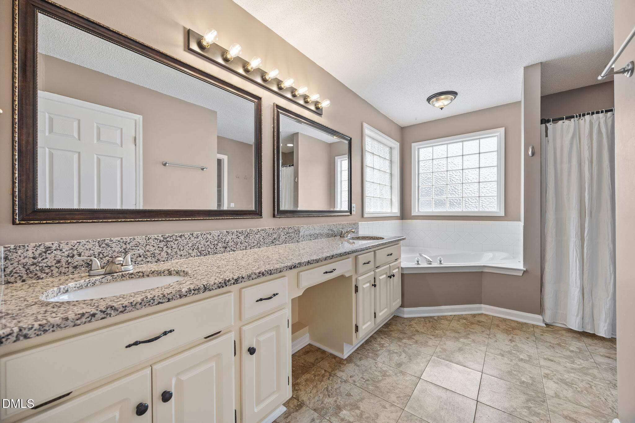 115 Edmondson Drive Willow Spring, NC 27592 - Photo 17 of 39 a bathroom with a granite countertop double vanity sink a mirror and a bathtub