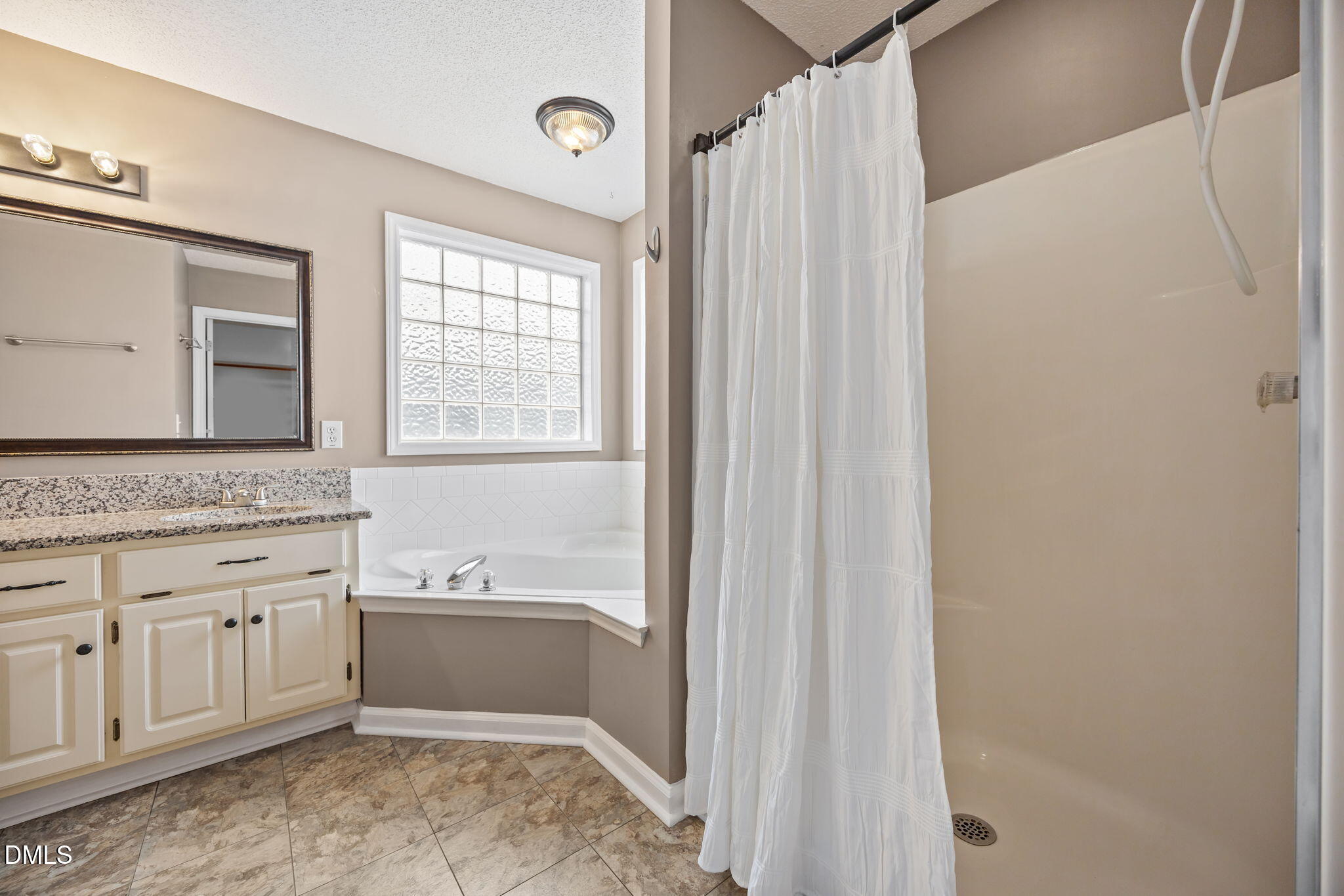 115 Edmondson Drive Willow Spring, NC 27592 - Photo 18 of 39 a bathroom with a granite countertop sink mirror and a bathtub