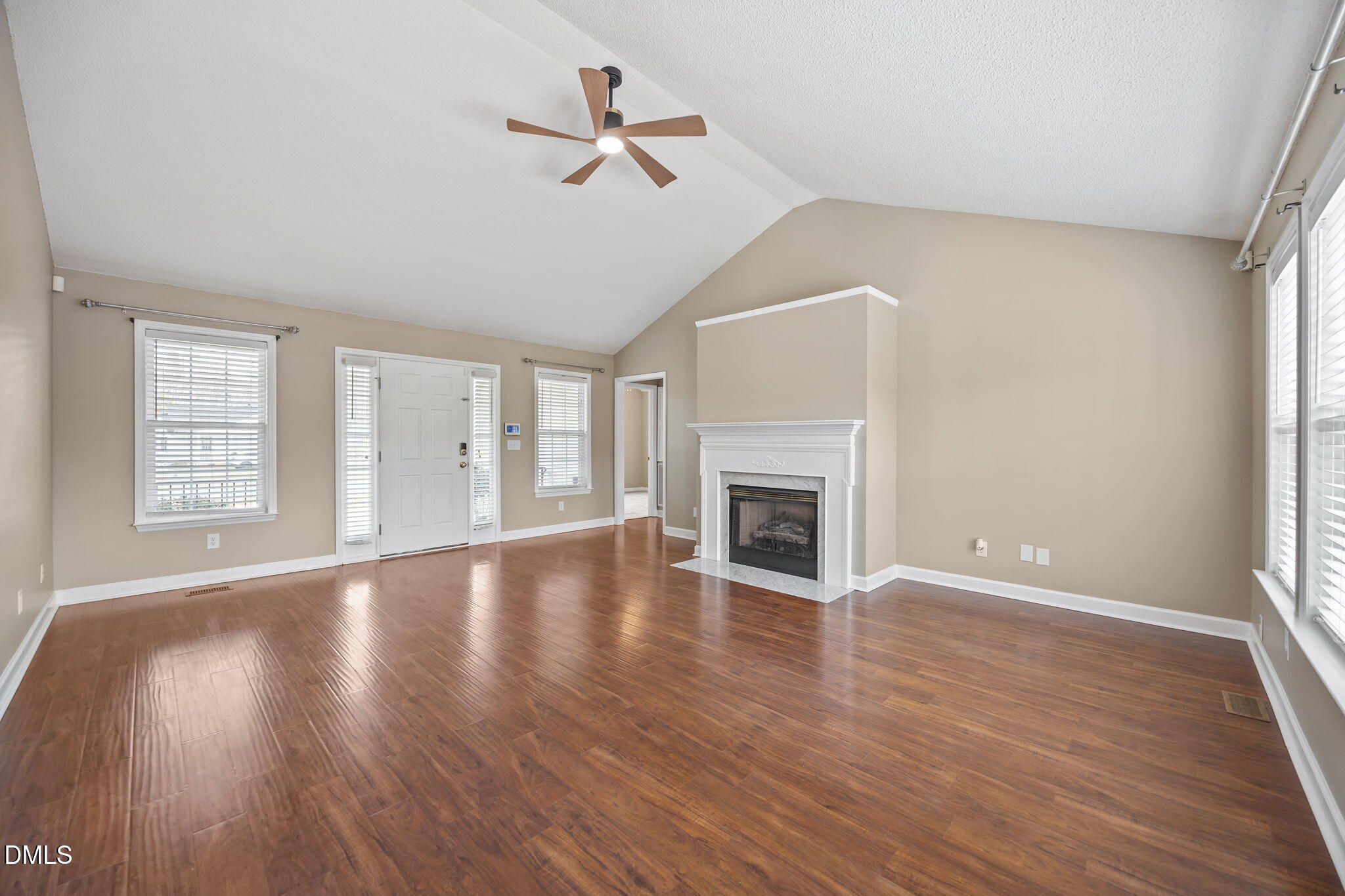 115 Edmondson Drive Willow Spring, NC 27592 - Photo 5 of 39 an empty room with wooden floor fireplace and windows