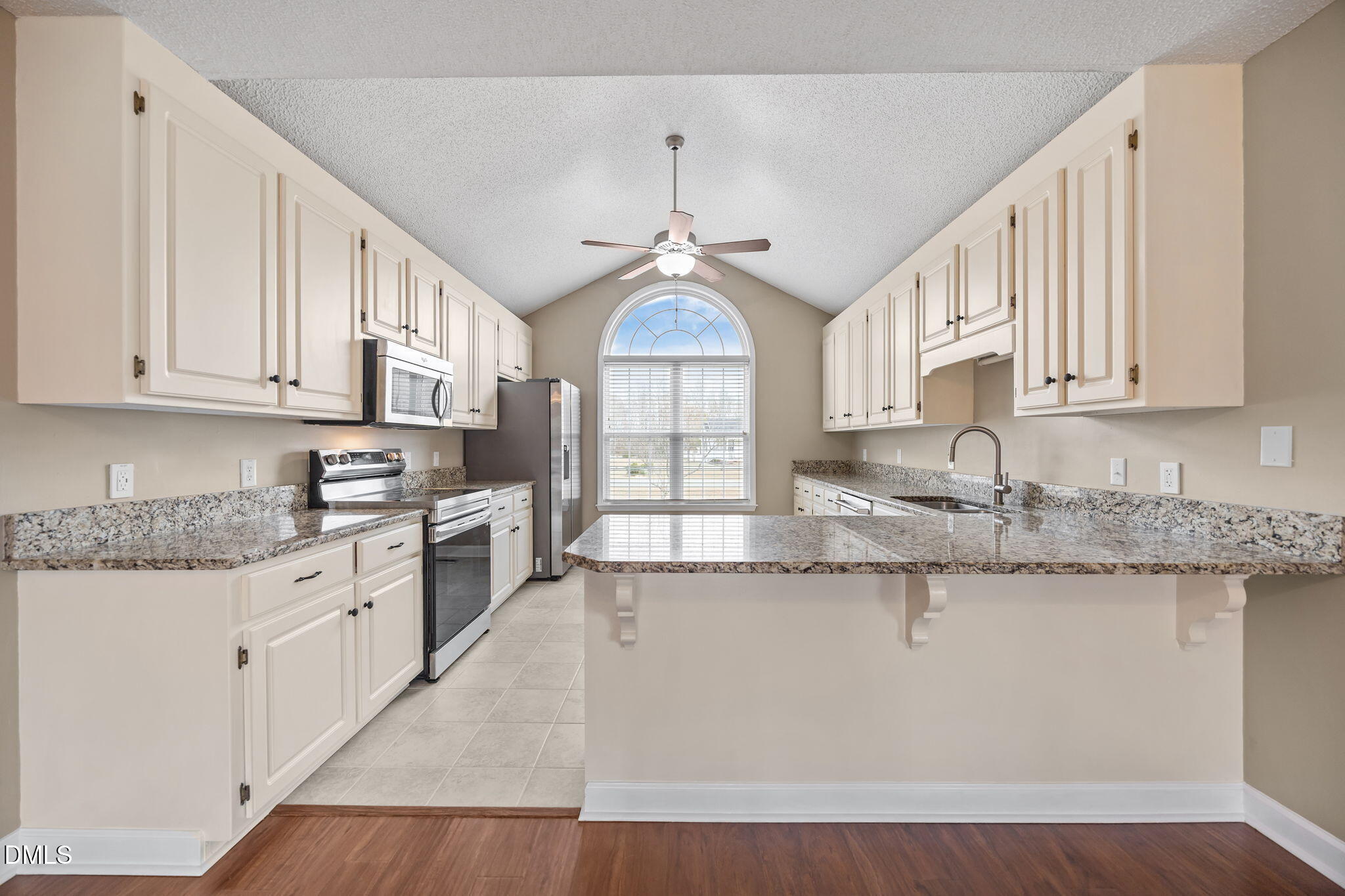115 Edmondson Drive Willow Spring, NC 27592 - Photo 9 of 39 a large kitchen with granite countertop a stove a sink dishwasher and a granite counter tops with white cabinets