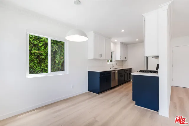 a large kitchen with a large counter top stainless steel appliances and a window