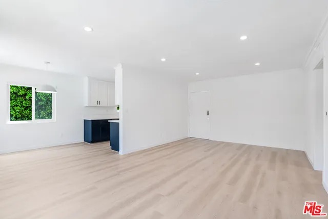 a view of empty room with wooden floor and window