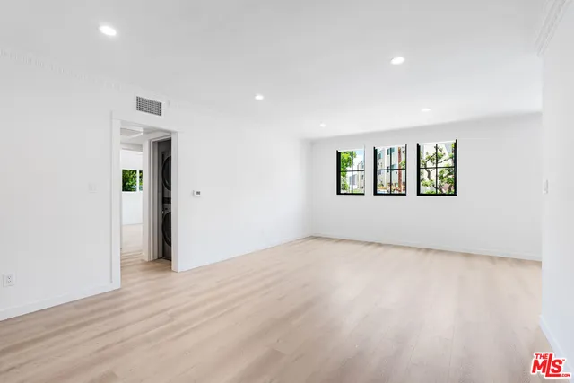 an empty room with windows and closet