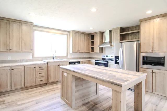 a kitchen with a refrigerator a sink dishwasher a stove with white cabinets and wooden floor