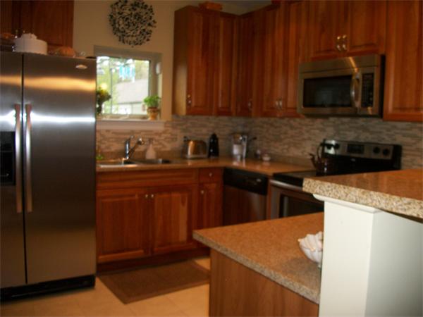 906 Alder Way, Unit 906 North Andover, MA 01845 - Photo 3 of 17 a kitchen with stainless steel appliances granite countertop a sink a stove a refrigerator a microwave oven with cabinets