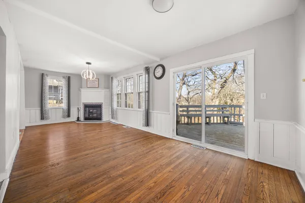 a view of empty room with wooden floor and fireplace