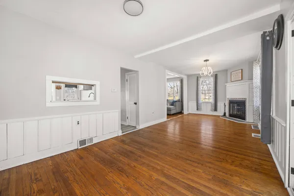 a view of a bedroom with wooden floor and windows