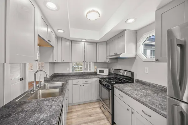 a view of empty room with wooden floor and fireplace