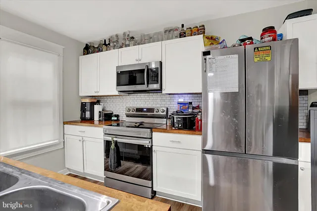 a white refrigerator freezer and a stove sitting inside of a kitchen