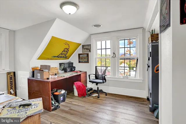 a view of a workspace with furniture and a window