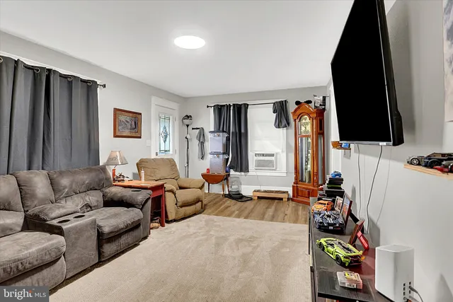 a living room with furniture a flat screen tv and a couch